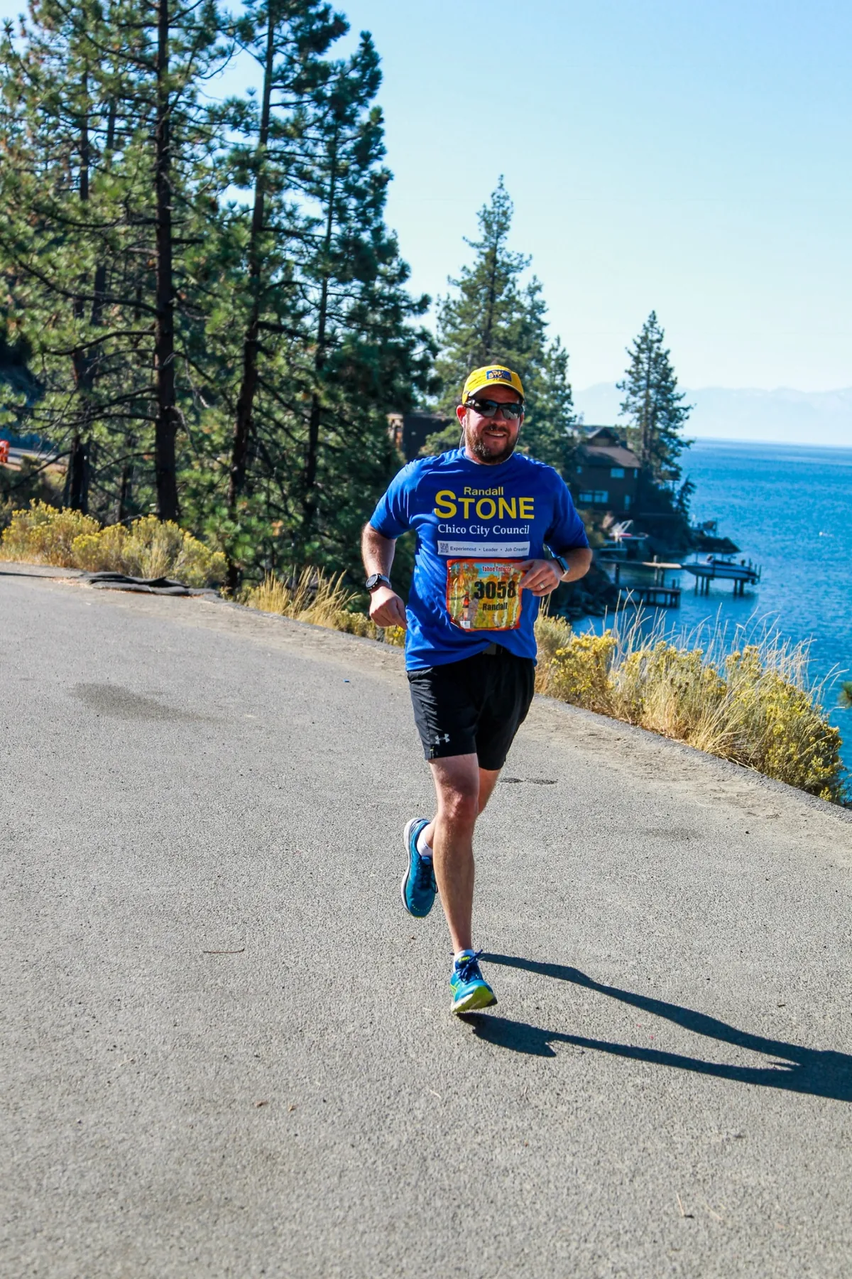 Randall Stone running beside Lake Tahoe in a Randall Stone Chico City Council shirt
